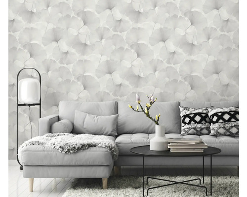 Wohnzimmer mit grauer Couch, Tisch und floraler Tapete