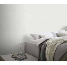 Helles Schlafzimmer mit Bett, Decken und Beistelltisch