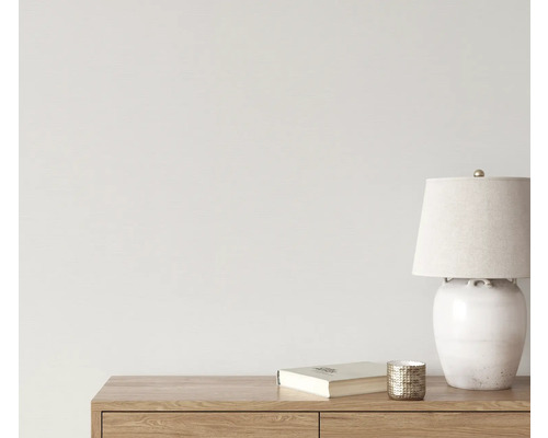 Dekorative Szene mit Tischleuchte, Buch und Kerzenhalter auf einem Holzmöbel