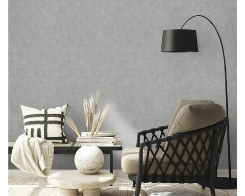 Wohnzimmer mit grauer Betonoptik-Tapete, Sessel und Stehlampe