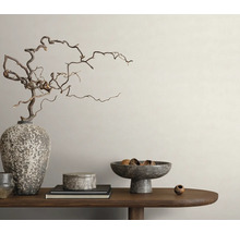 Dekorative Anordnung mit Vase, Ästen, Schalen und Büchern auf einem Holztisch