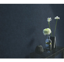 Dekorative Vasen mit Blumen auf einem Tisch vor einer Wand