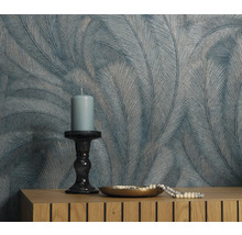 Dekorative Wand mit Feder-Tapete, Kerze und Schmuck auf Kommode