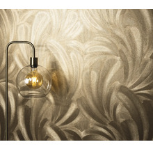 Nahaufnahme einer Tapete mit Federdesign neben einer Stehlampe mit einer Glühbirne in einer Glaskugel