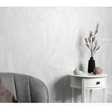 Helle Tapete mit Federdesign, Beistelltisch mit Vasen und Dekoration, Sessel im Raum