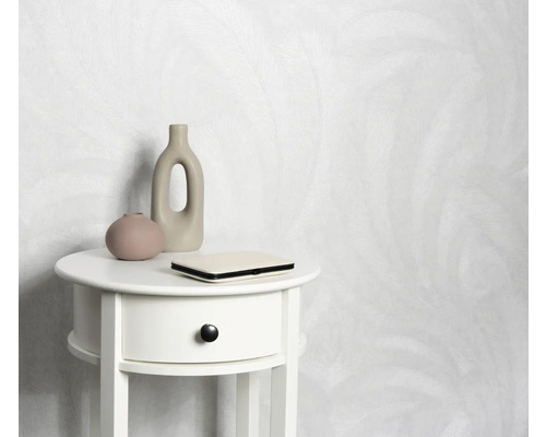 Helle Tapete mit Muster hinter einem weißen Nachttisch mit Dekoration