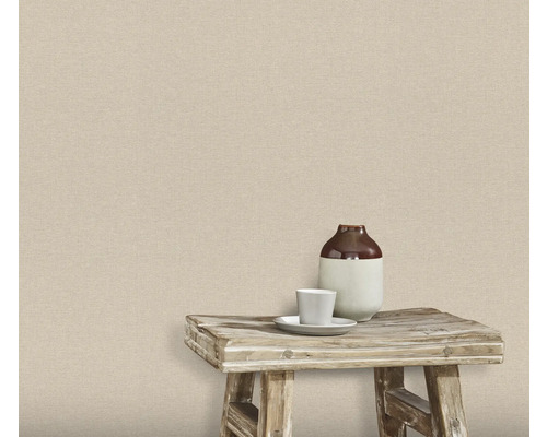 Wand mit Textiltapete, darauf ein Hocker mit Vase und Tasse