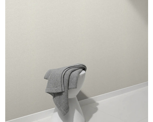 Ein grauer Überwurf liegt auf einem weißen Hocker