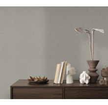 Nahaufnahme einer grauen Struktur-Tapete über einer Kommode mit Dekorationsgegenständen.