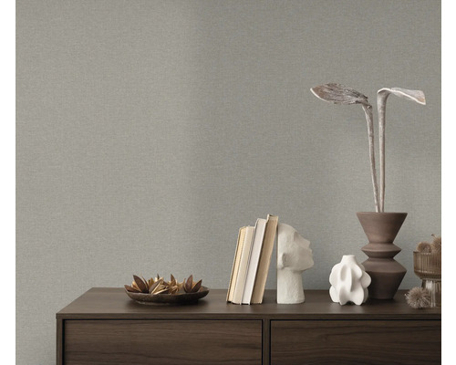 Nahaufnahme einer grauen Struktur-Tapete über einer Kommode mit Dekorationsgegenständen.