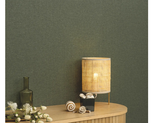 Nahaufnahme einer grünen Textiltapete mit Tischlampe und Dekoration