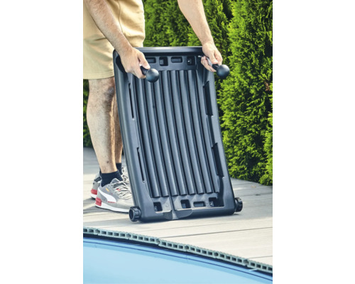 Person trägt Solarabsorber zur Schwimmbadheizung