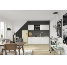 Helle Küche mit Essbereich, ausgestattet mit Küchenschränken, Esstisch, Stühlen und einem Retro-Kühlschrank.