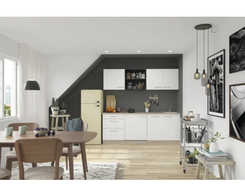 Helle Küche mit Essbereich, ausgestattet mit Küchenschränken, Esstisch, Stühlen und einem Retro-Kühlschrank.