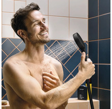 Mann unter der Dusche mit Handbrause in der Hand