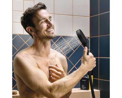 Mann unter der Dusche mit Handbrause in der Hand
