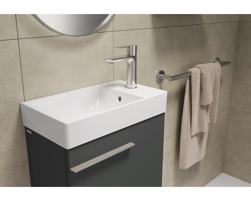 Waschtisch mit Waschbecken, Armatur und Handtuchhalter im Badezimmer