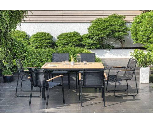 Gartenszene mit Gartentisch und Stühlen auf Terrasse, umgeben von Pflanzen