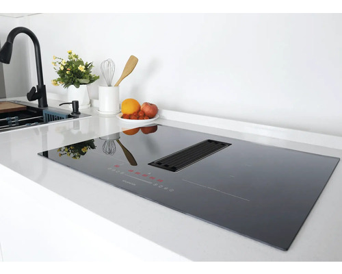 Schwarzes Induktionskochfeld mit Dunstabzugshaube auf einer Küchentheke