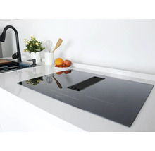 Schwarzes Induktionskochfeld mit integriertem Dunstabzug in einer modernen Küche.