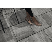 Graue Pflastersteine mit sitzender Person