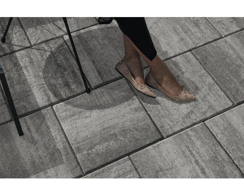 Graue Pflastersteine mit sitzender Person