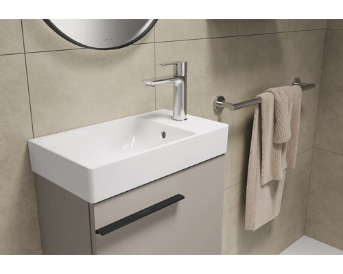 Badezimmer Waschbecken mit Unterschrank, Armatur und Handtuchhalter.