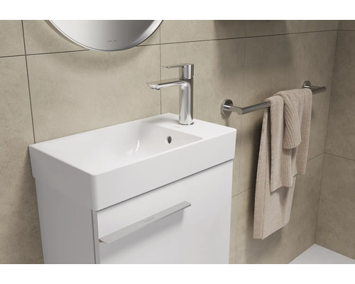 Helles Badezimmer mit Waschbeckenunterschrank, Armatur und Handtuchhalter