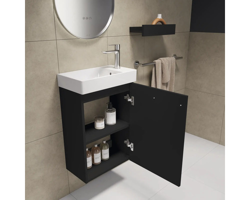 Badezimmer mit Waschbecken, Unterschrank mit offener Tür, Regal und Spiegel