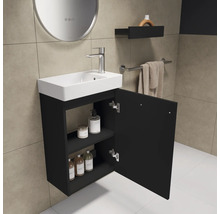 Badezimmer mit Waschbecken, Unterschrank und geöffneter Tür zur Aufbewahrung von Badutensilien