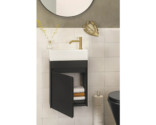 Badezimmer mit Waschbecken, Unterschrank, Handtüchern, Toilettenpapier und Dekoration