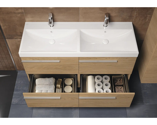 Badezimmer mit Doppelwaschtisch aus Holz und zwei offenen Schubladen mit Badutensilien