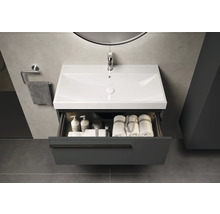 Waschtischunterschrank mit geöffneter Schublade, Waschbecken, Handtüchern und Pflegeprodukten im Badezimmer
