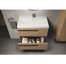 Badezimmer mit Waschtischunterschrank aus Holz, Waschbecken und geöffneter Schublade