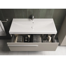 Badezimmer mit Waschtischunterschrank, Waschbecken, Armatur und offenem Schubladenfach mit Handtüchern und Badutensilien