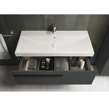 Waschtisch mit offenem Schubfach, darin Handtücher und Badezimmerartikel