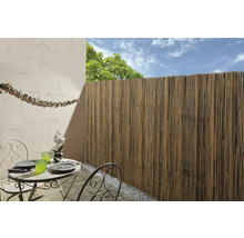 Außenbereich mit Bambuszaun, Tisch und Stühlen