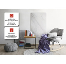 Wohnzimmer mit Infrarotheizungspaneel, Sessel, Beistelltisch und Dekoration