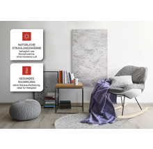 Wohnraum mit Infrarotheizung, Sessel, Beistelltisch und Dekoration