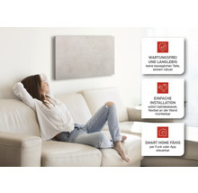 Frau entspannt auf Sofa unter Infrarotheizung mit den Vorteilen: Wartungsfrei, einfache Installation und Smart Home fähig