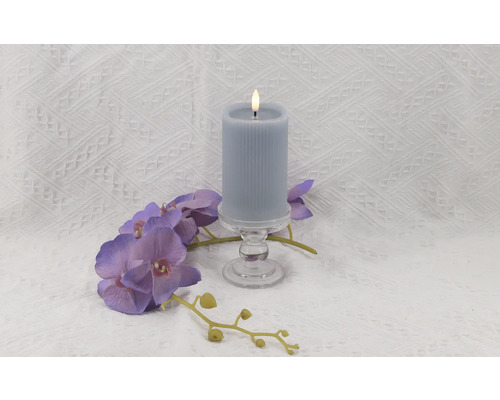Dekorative LED-Kerze auf Glasständer mit lila Orchideenblüten