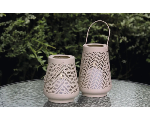 Zwei dekorative Windlichter mit Griff und Lochmuster auf einem Tisch