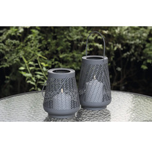 Zwei graue Windlichter mit Muster auf einem Tisch