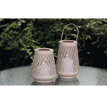 Zwei dekorative Windlichter mit Tragegriffen und geometrischem Muster stehen auf einem Tisch.