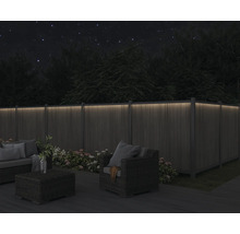 Nachts beleuchteter Garten mit Holzzaun und Gartenmöbeln