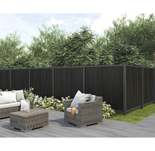 Gartenszene mit Zaun aus Holz, Loungemöbeln und Pflanzen für einen stilvollen Außenbereich