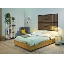 Helles Schlafzimmer mit Bett, Nachttisch, Lampe, Sessel und Regal