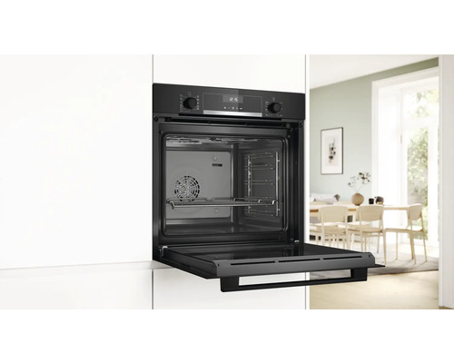 Einbauofen mit geöffneter Tür in einer hellen Küche.