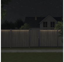 Nachtsicht einer Holzgartenpforte mit Haus im Hintergrund