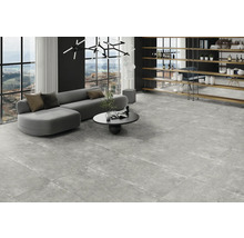 Heller Wohnraum mit grauem Sofa, Couchtisch und Bodenfliesen